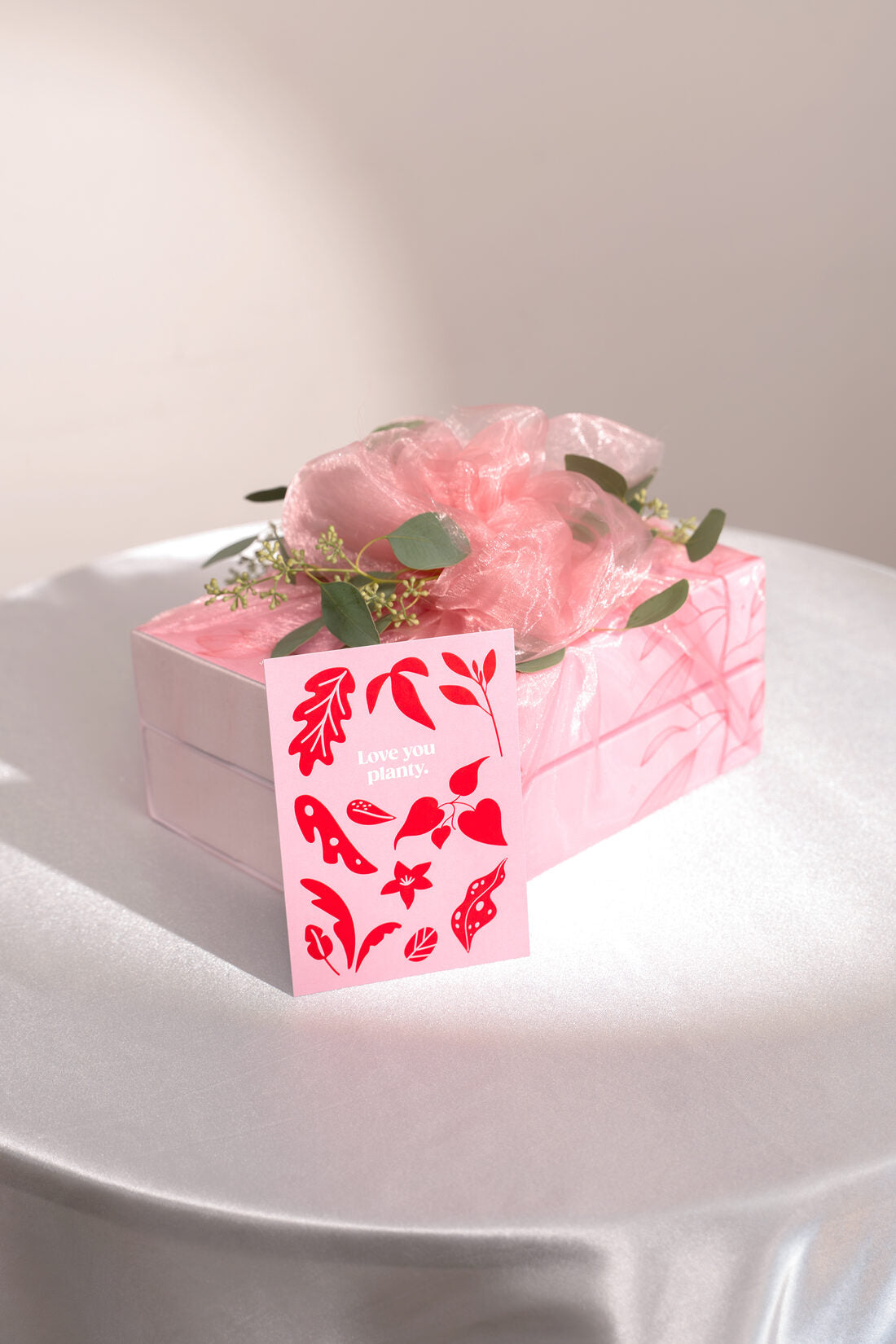 Im rosa Organzatuch gebundenes Hochzeitsgeschenk mit Eukalyptus